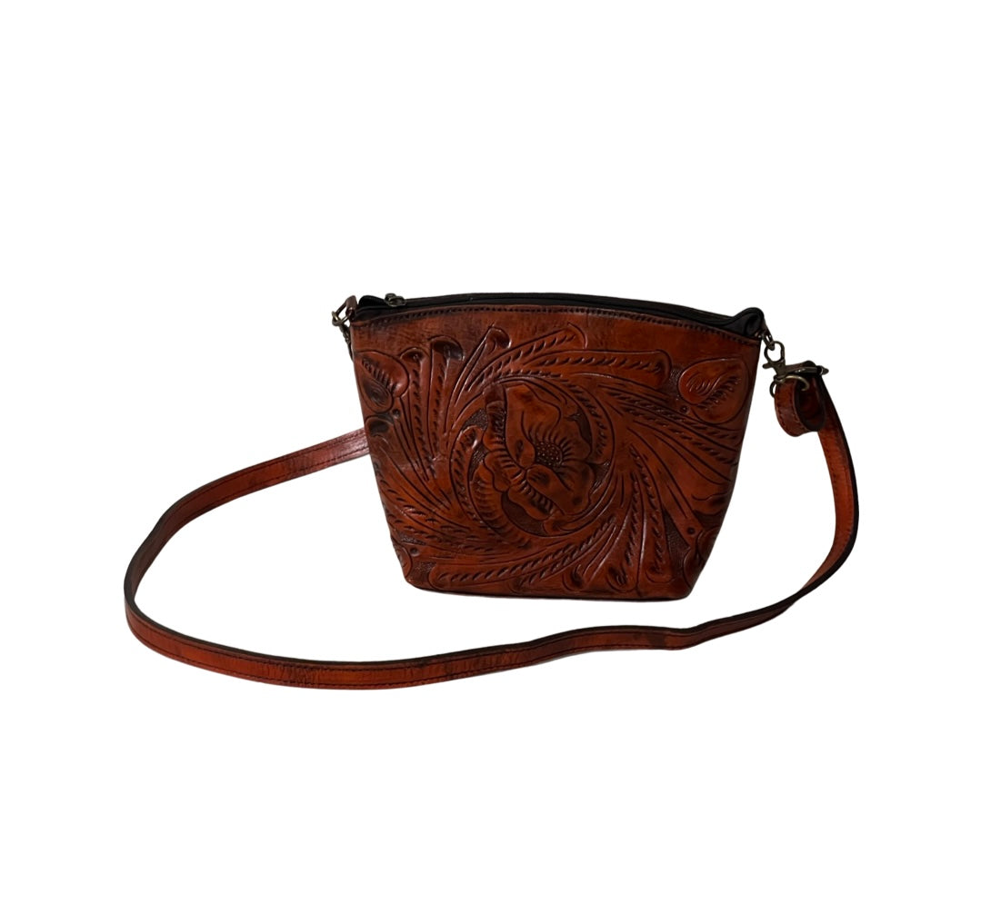 Small sized full leather crossbody with a traditional mexican design all around the purse. Fully lined with suede.  Zipper on top and detachable strap. In color chadron / burned orange