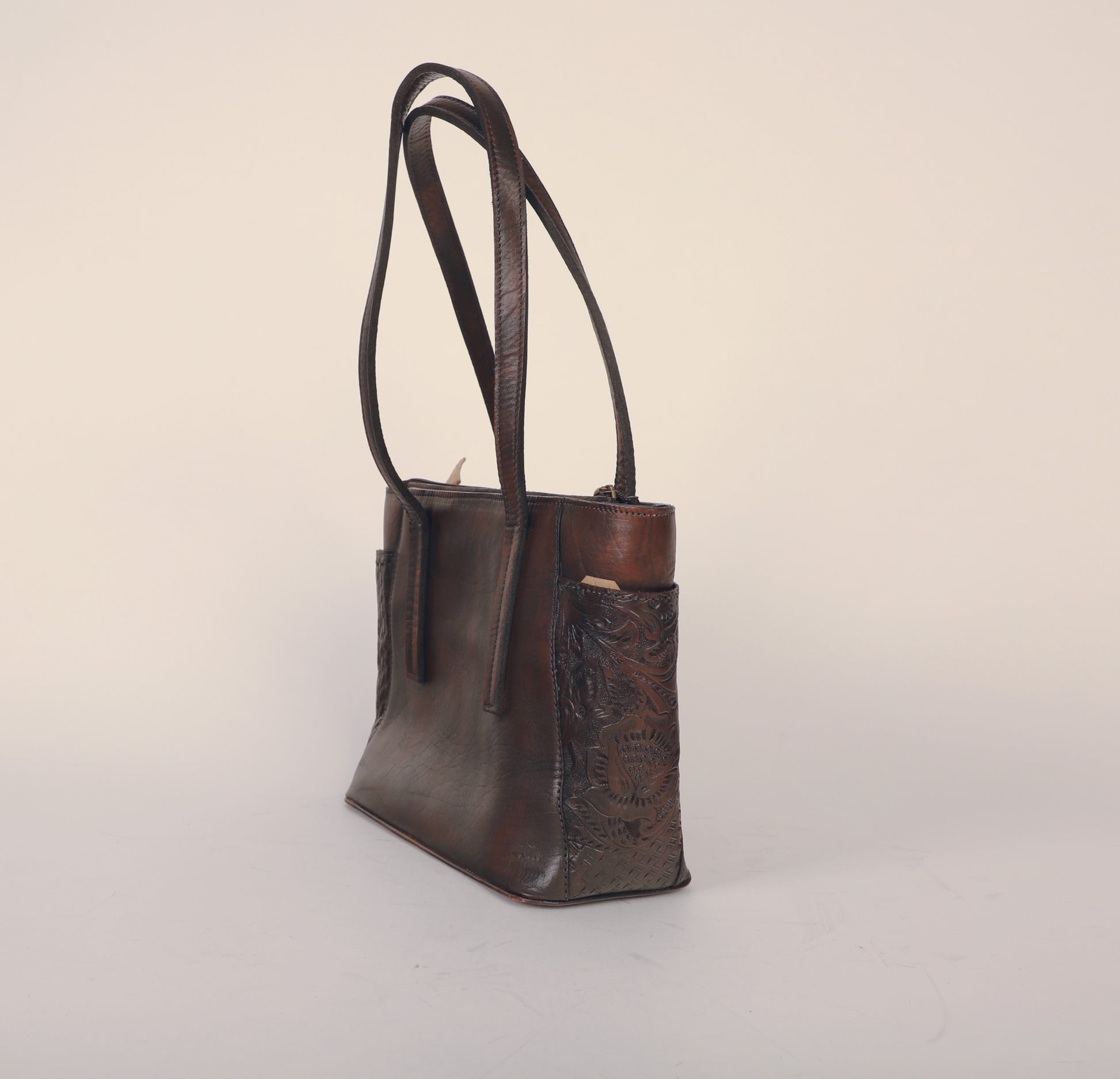 Medium-sized full leather tote bag with traditional Mexican design on side pockets. Fully lined with suede with strap length displayed. Color Chadron or brown.