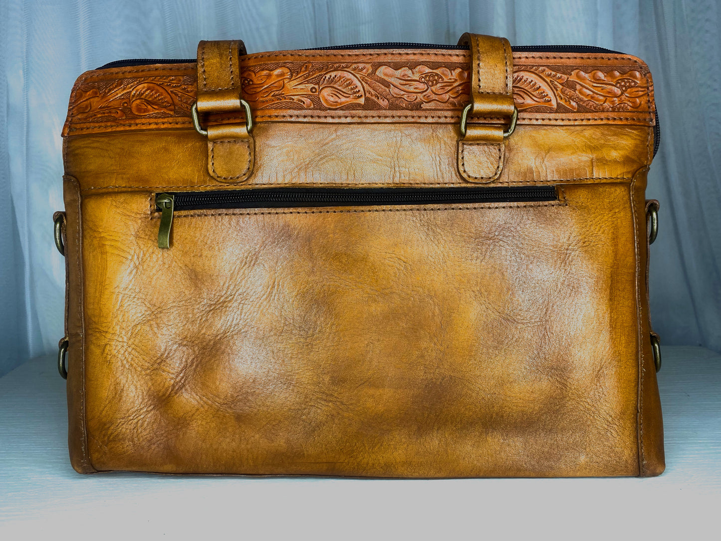 Medium-sized full leather messenger bag with one inch of traditional mexican Etching on the upper portion of the bag. Fully lined with suede.  On camel color