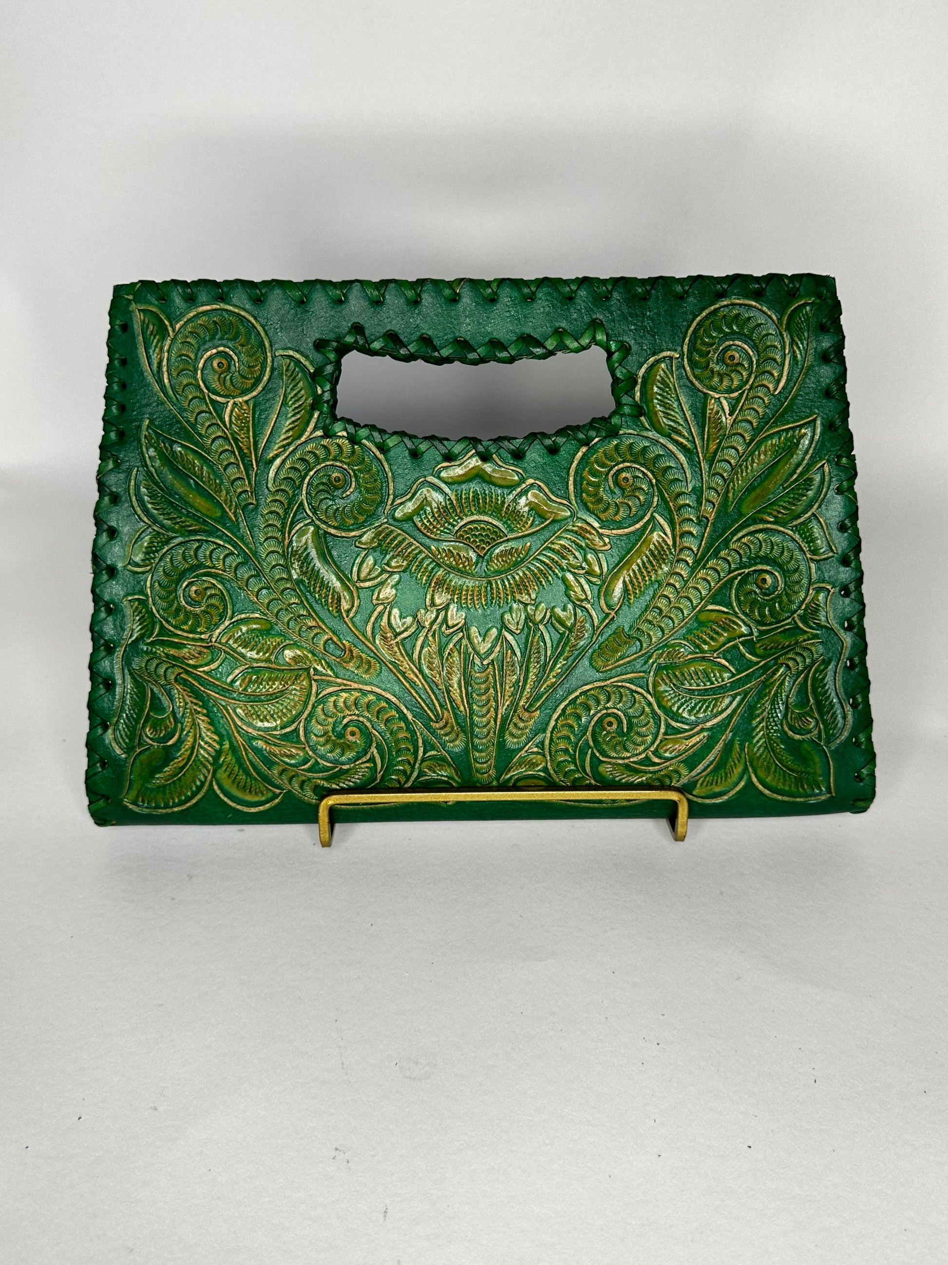 Small Mexican leather handbag with traditional design hand etched throughout the bag. Has handle mid top. leather stitching all around. Color viper green. 